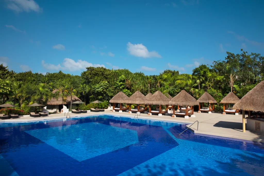 Tranquil pool surrounded by private cabanas and tropical gardens at Dreams Sapphire Resort & Spa.