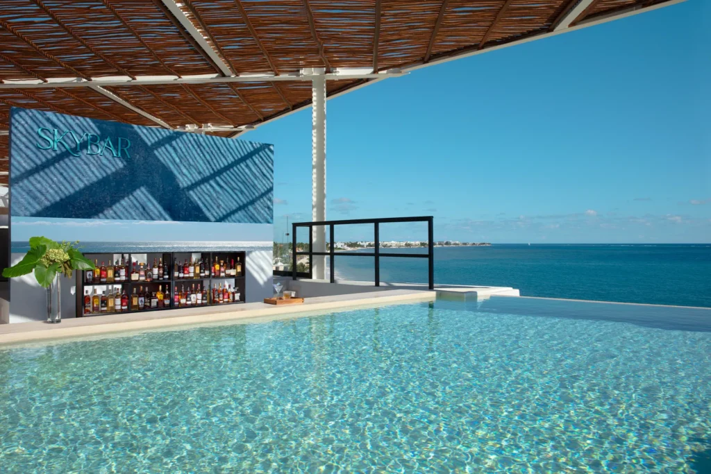 Sky Bar at Dreams Sapphire Resort & Spa featuring a stylish rooftop lounge, handcrafted cocktails, and panoramic views of the Caribbean coastline.