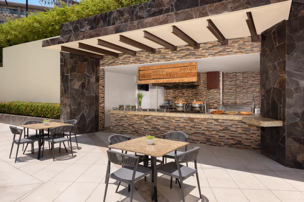 Barefoot Grill at Dreams Vallarta Bay Resort & Spa featuring a casual open-air poolside grill serving lunch with outdoor seating.