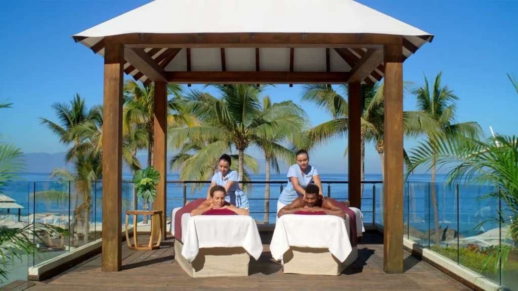 Couple enjoying a beachfront couples massage at Dreams Vallarta Bay Resort & Spa in Puerto Vallarta.