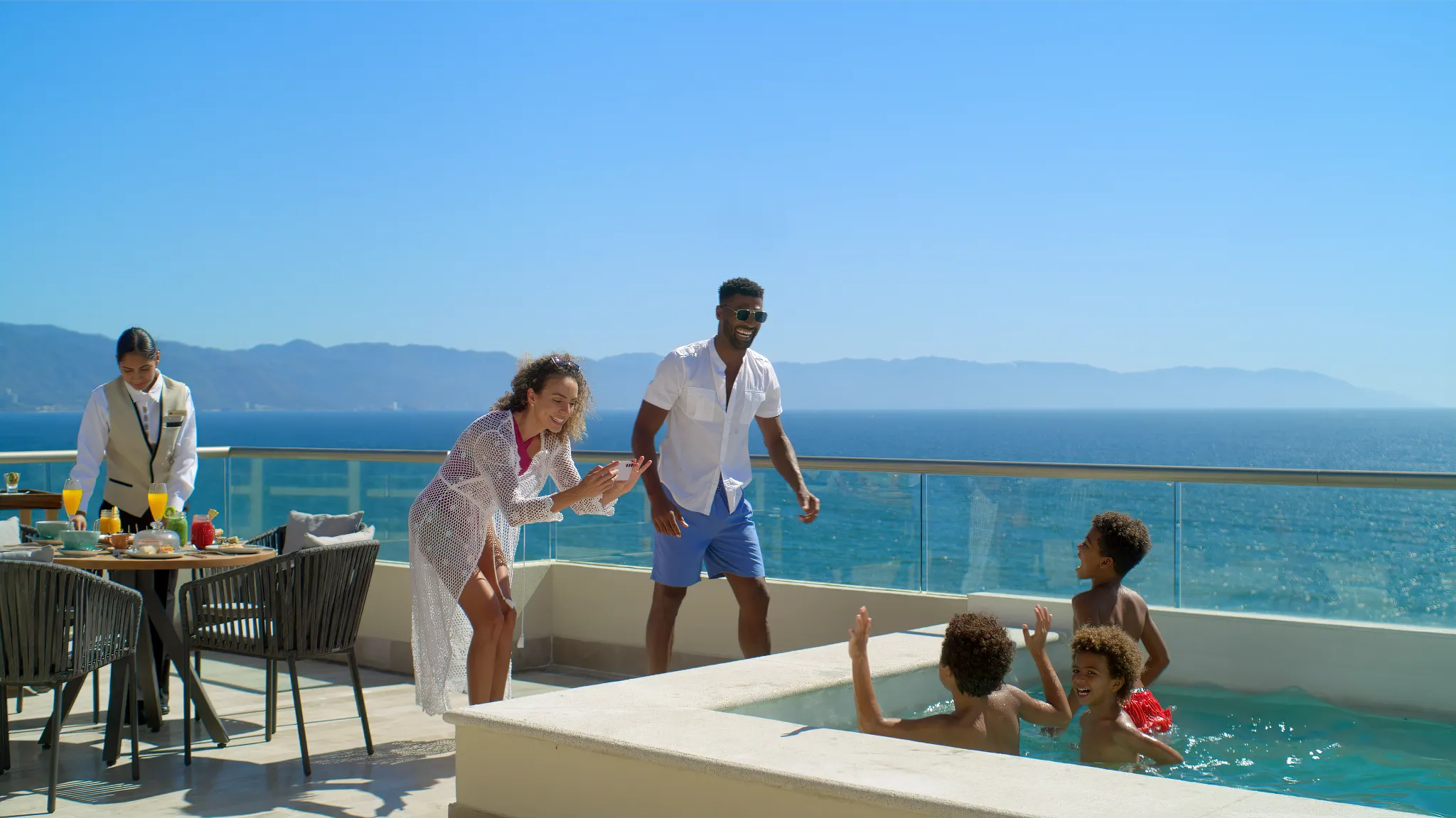 Family relaxing in a private terrace plunge pool with ocean views at Dreams Vallarta Bay Resort & Spa.