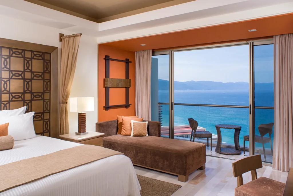 Junior Suite Ocean View with king bed, sofa seating, and private balcony at Dreams Vallarta Bay Resort & Spa.