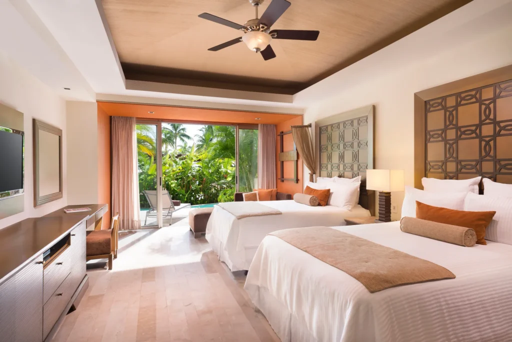 Junior Suite Swim Out with two double beds and terrace access to a pool at Dreams Vallarta Bay Resort & Spa.
