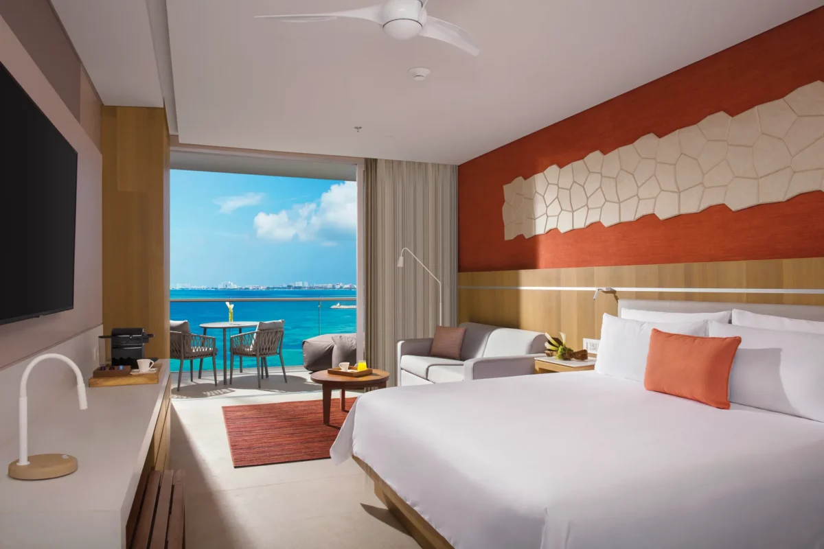Deluxe Ocean View room with king bed and private balcony overlooking turquoise Caribbean waters at Dreams Vista Cancun.