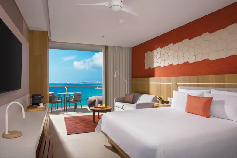 Deluxe Ocean View room with king bed and private balcony overlooking turquoise Caribbean waters at Dreams Vista Cancun.