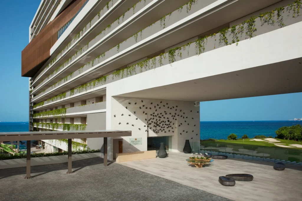 Modern entrance and lobby exterior at Dreams Vista Cancun Golf & Spa Resort with ocean and golf course views.