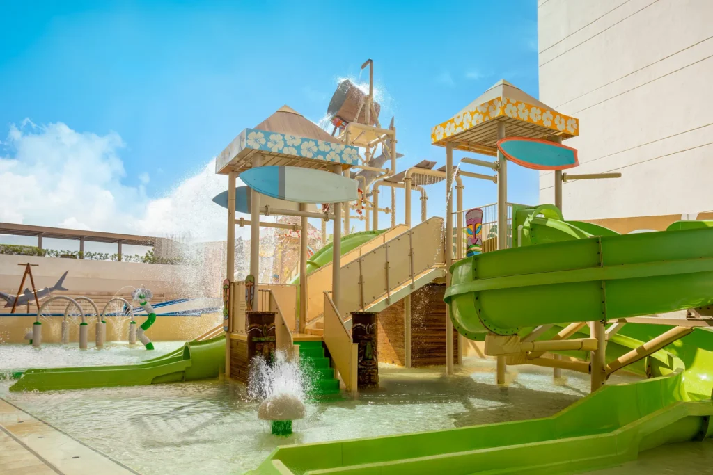 Child learning to surf on a wave simulator at Dreams Vista Cancun Golf & Spa Resort.