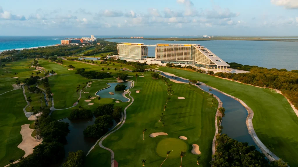 Aerial view of Hyatt Vivid Grand Island resort buildings next to lush golf course and waterways.