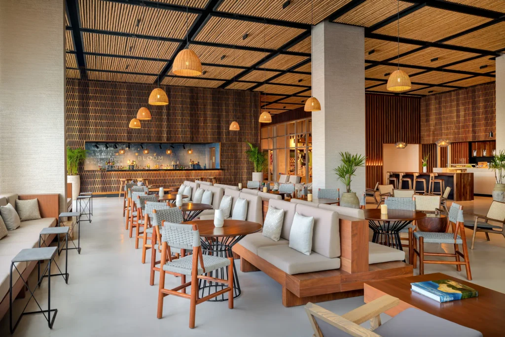 Modern lobby bar with wooden design and lounge seating at Hyatt Vivid Grand Island, perfect for cocktails and socializing.
