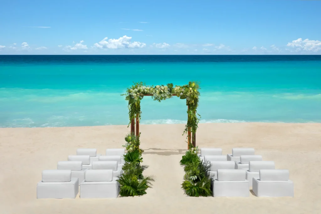 Ennea Beach Area wedding ceremony setup with floral arch overlooking turquoise ocean at Hyatt Vivid Grand Island