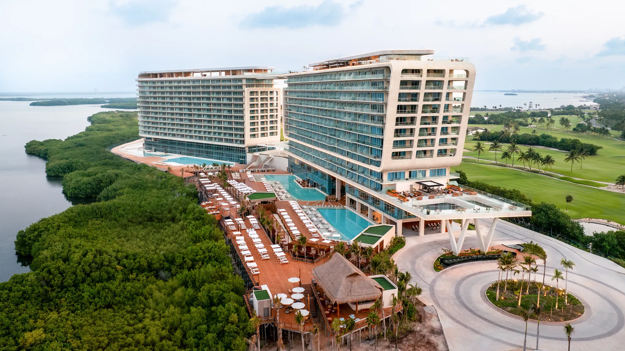 Exterior view of Hyatt Vivid Grand Island with modern architecture, pools, and surrounding nature.