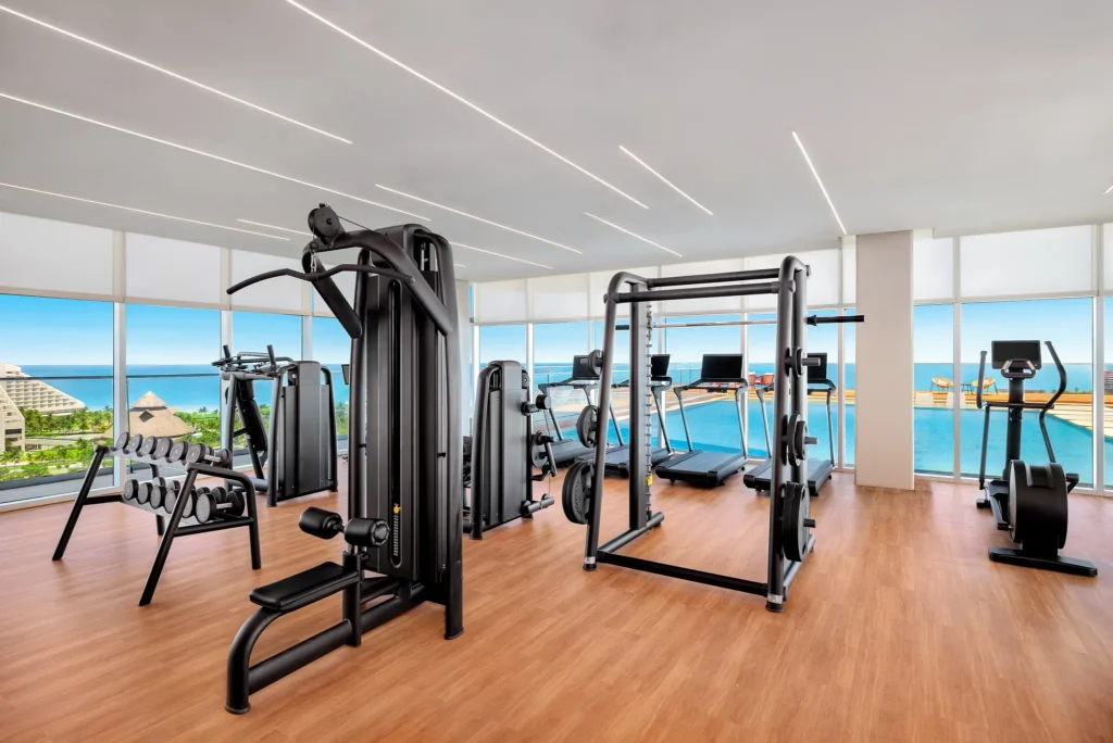 Modern fitness center with strength machines and ocean views at Hyatt Vivid Grand Island.