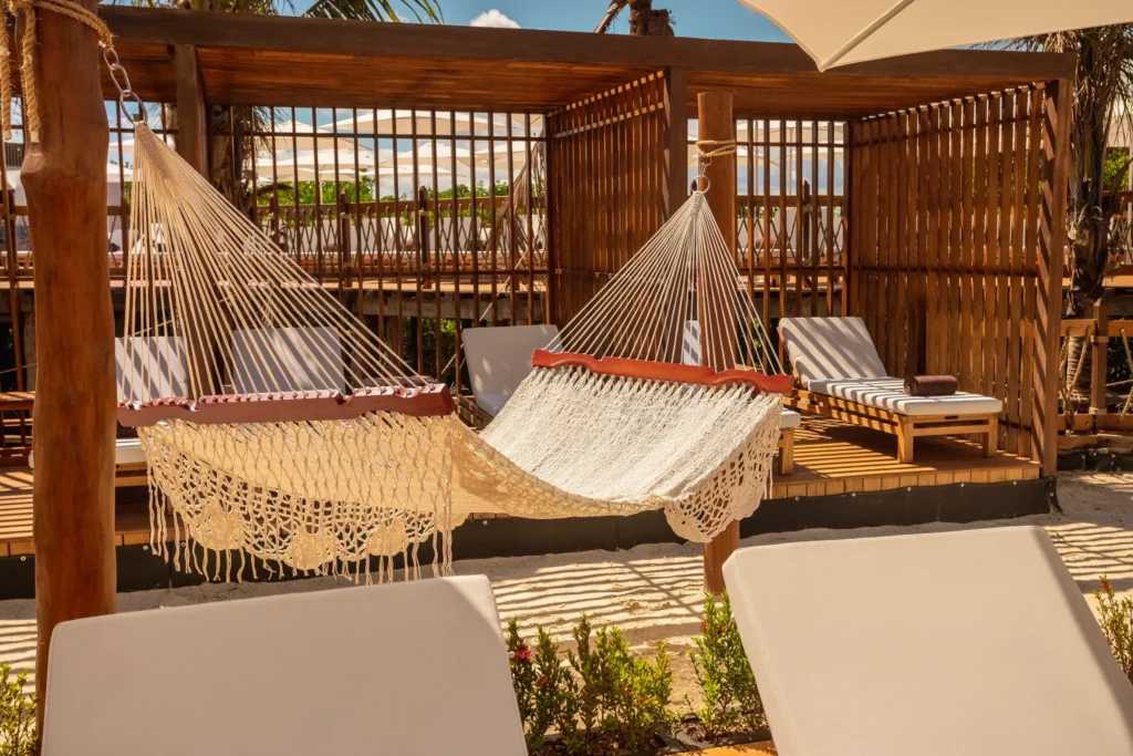 Hammocks and lounge chairs in a private beach cabana at Hyatt Vivid Grand Island, offering a relaxing adults-only escape in Cancun.
