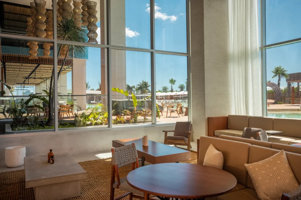 Bright lobby lounge with modern seating and large windows overlooking the pool at Hyatt Vivid Grand Island.