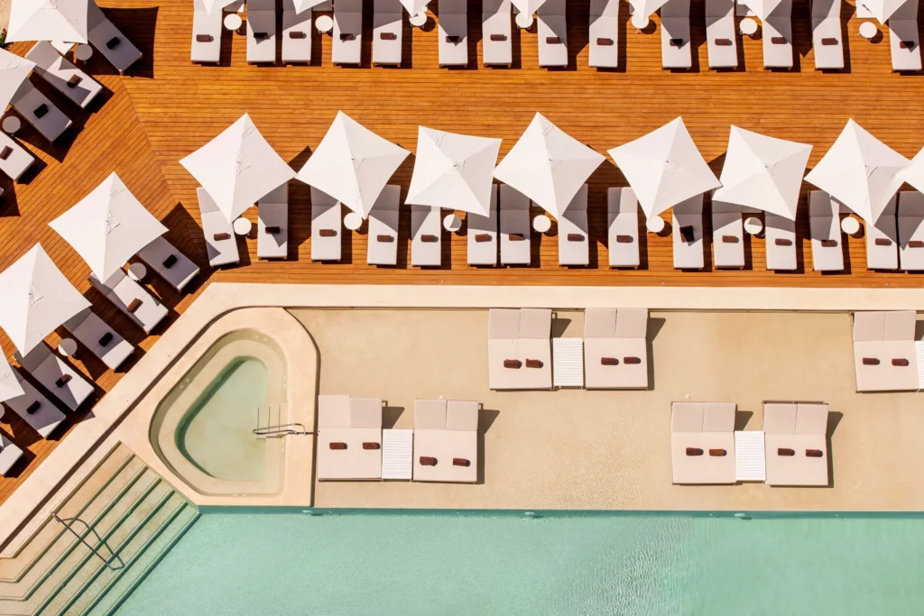 Overhead view of main pool deck with lounge chairs and umbrellas at Hyatt Vivid Grand Island.