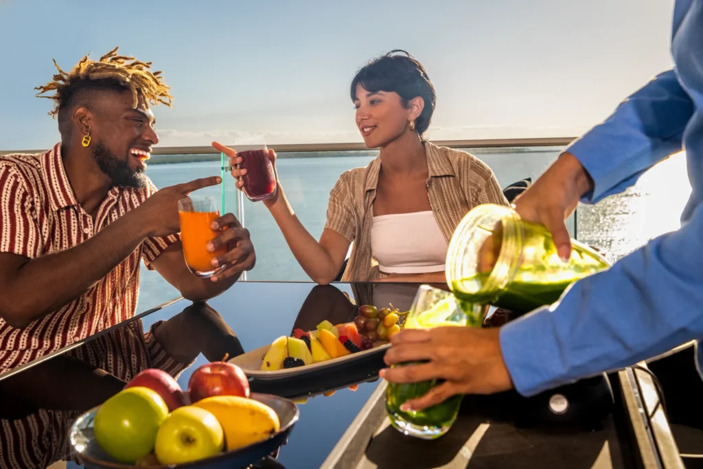 Guests enjoying drinks on a rooftop terrace overlooking the water at Hyatt Vivid Grand Island.