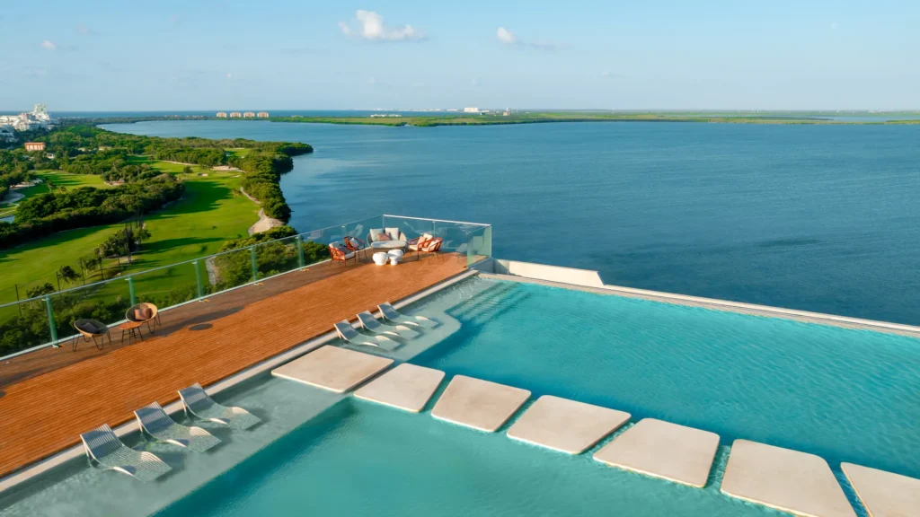 Rooftop infinity pool overlooking lagoon with lounge chairs at Hyatt Vivid Grand Island.
