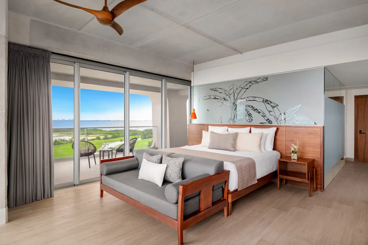 Vantage Club Corner Suite Bay View with king bed, lounge area, and private balcony at Hyatt Vivid Grand Island.