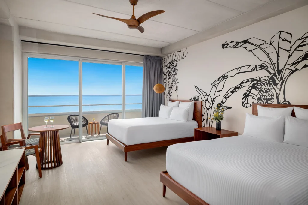 Vantage Club Junior Suite Bay View with two double beds and private balcony overlooking the bay at Hyatt Vivid Grand Island.