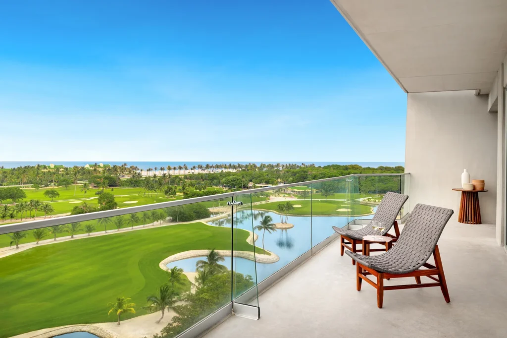 Private balcony terrace with lounge chairs overlooking golf course and ocean at Hyatt Vivid Grand Island Vantage Club Master Suite.