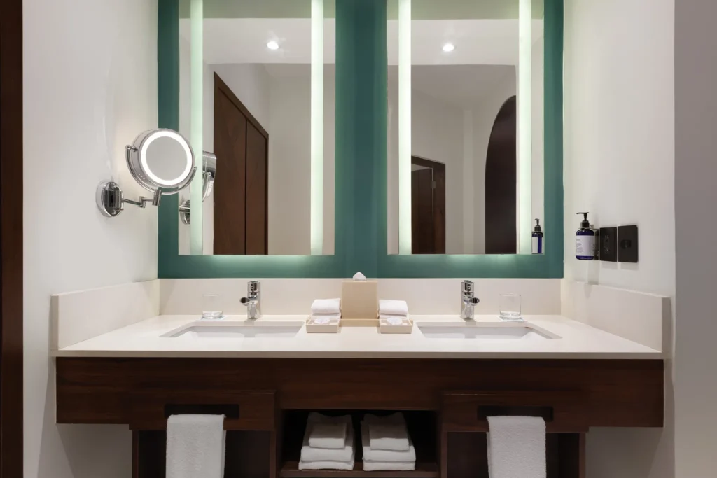 Junior Suite Swim-Up bathroom with double vanities and illuminated mirrors at Hyatt Vivid Playa del Carmen.