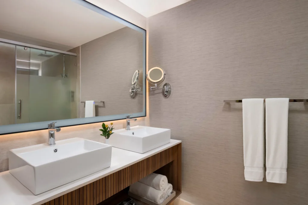 Deluxe Pool View bathroom with double vanities and glass-enclosed shower at Hyatt Vivid Punta Cana.
