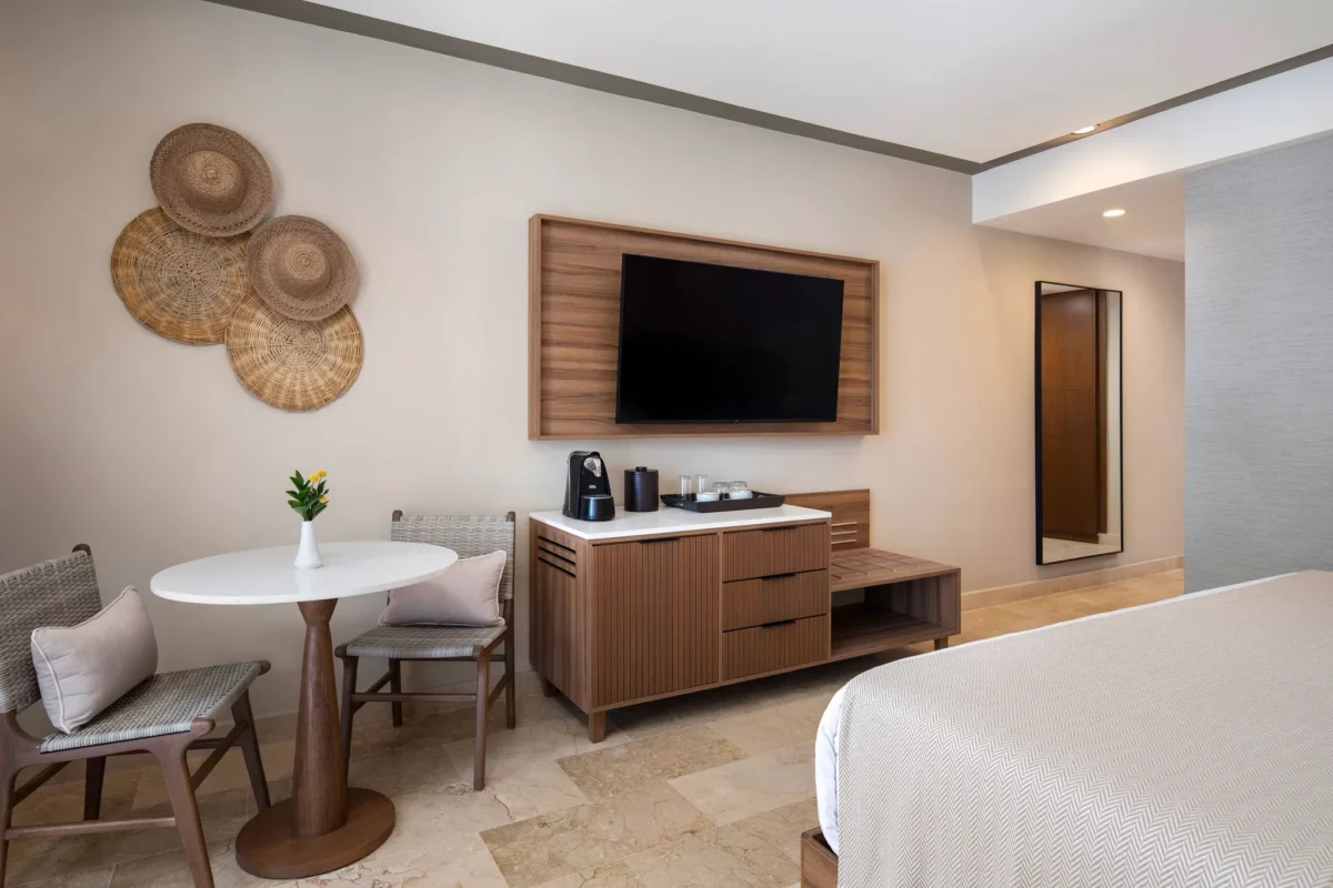 Deluxe Pool View room seating area with TV, coffee station, and modern furnishings at Hyatt Vivid Punta Cana.