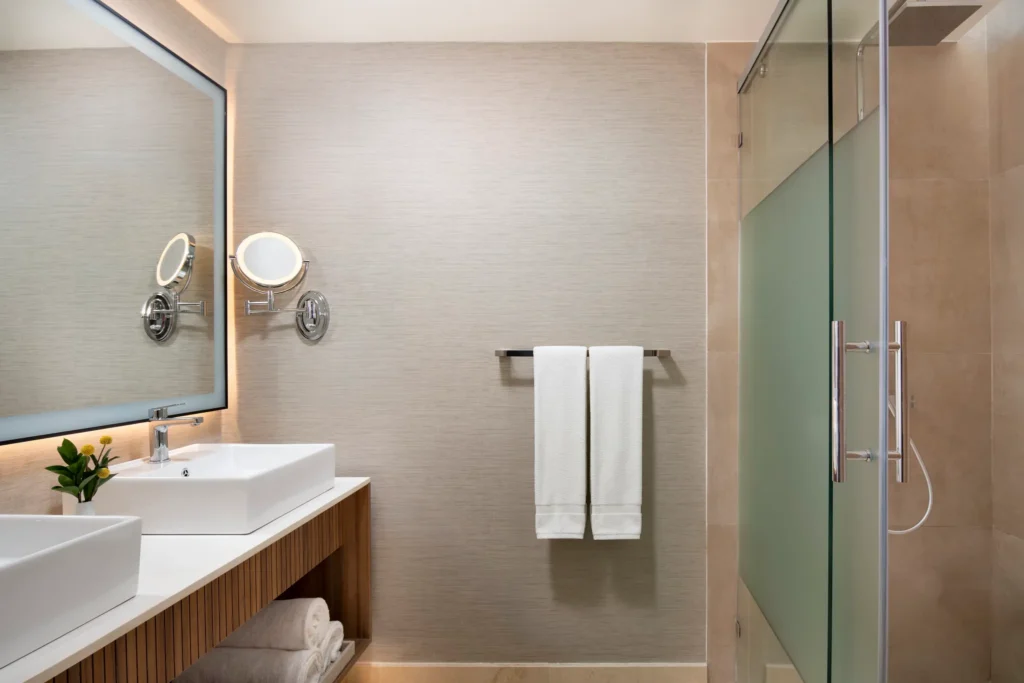 Hyatt Vivid Punta Cana bathroom with double vanities and glass-enclosed shower.