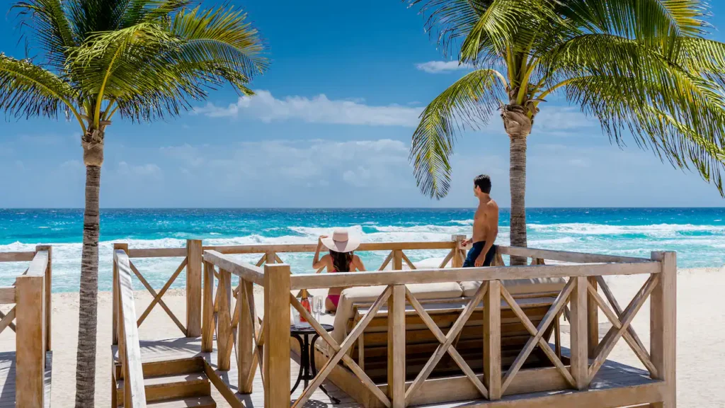 Couple relaxing in a beachfront cabana overlooking the Caribbean Sea at Hyatt Zilara Cancun.