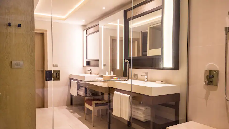 Modern bathroom with dual sinks and glass-enclosed shower in the Resort View Junior Suite King at Hyatt Zilara Cap Cana.