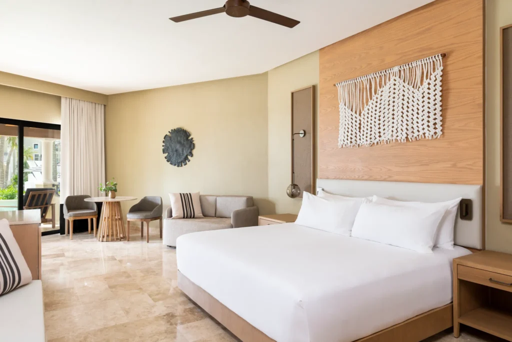 Club Level Junior Suite Pool View Swim Out King bedroom with seating area at Hyatt Zilara Riviera Maya.