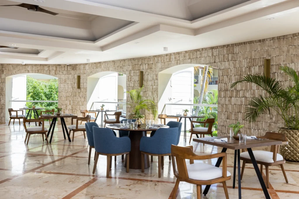 El Comedor buffet restaurant at Hyatt Zilara Riviera Maya featuring an elegant open-air dining space with stone walls, modern seating, and garden views.