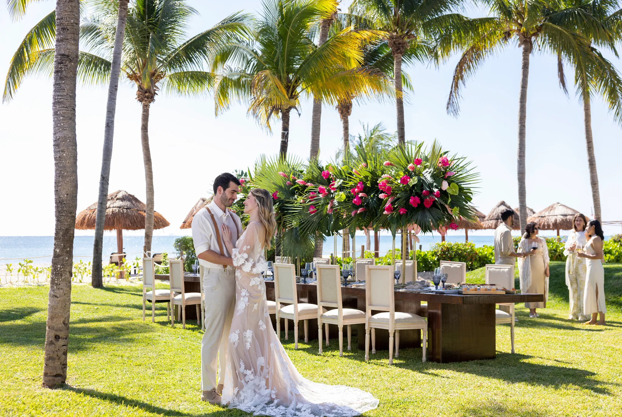 Newlywed couple at garden reception with tropical floral arrangements at Hyatt Zilara Riviera Maya
