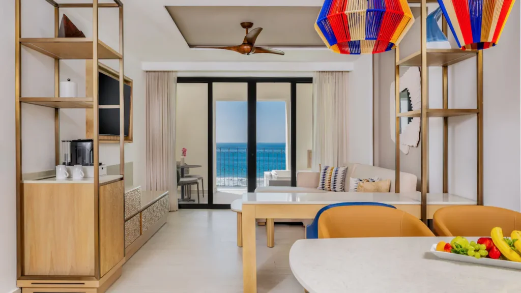 Club Deluxe Oceanfront One Bedroom Suite living room with dining area, ocean-view balcony, and seating at Hyatt Ziva Los Cabos.