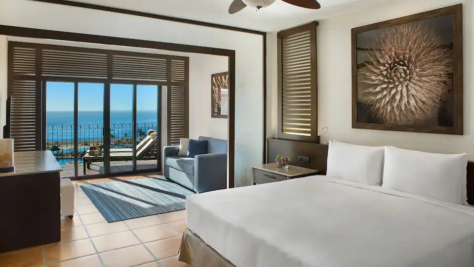 Club Oceanfront One Bedroom Master Suite with king bed, separate living room, and private oceanfront balcony at Hyatt Ziva Los Cabos.