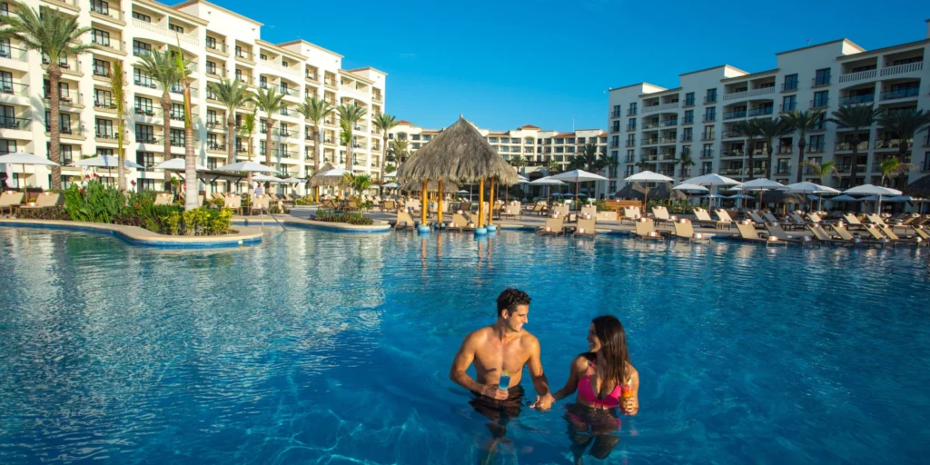 Couple enjoying drinks together in the resort pool at Hyatt Ziva Los Cabos.