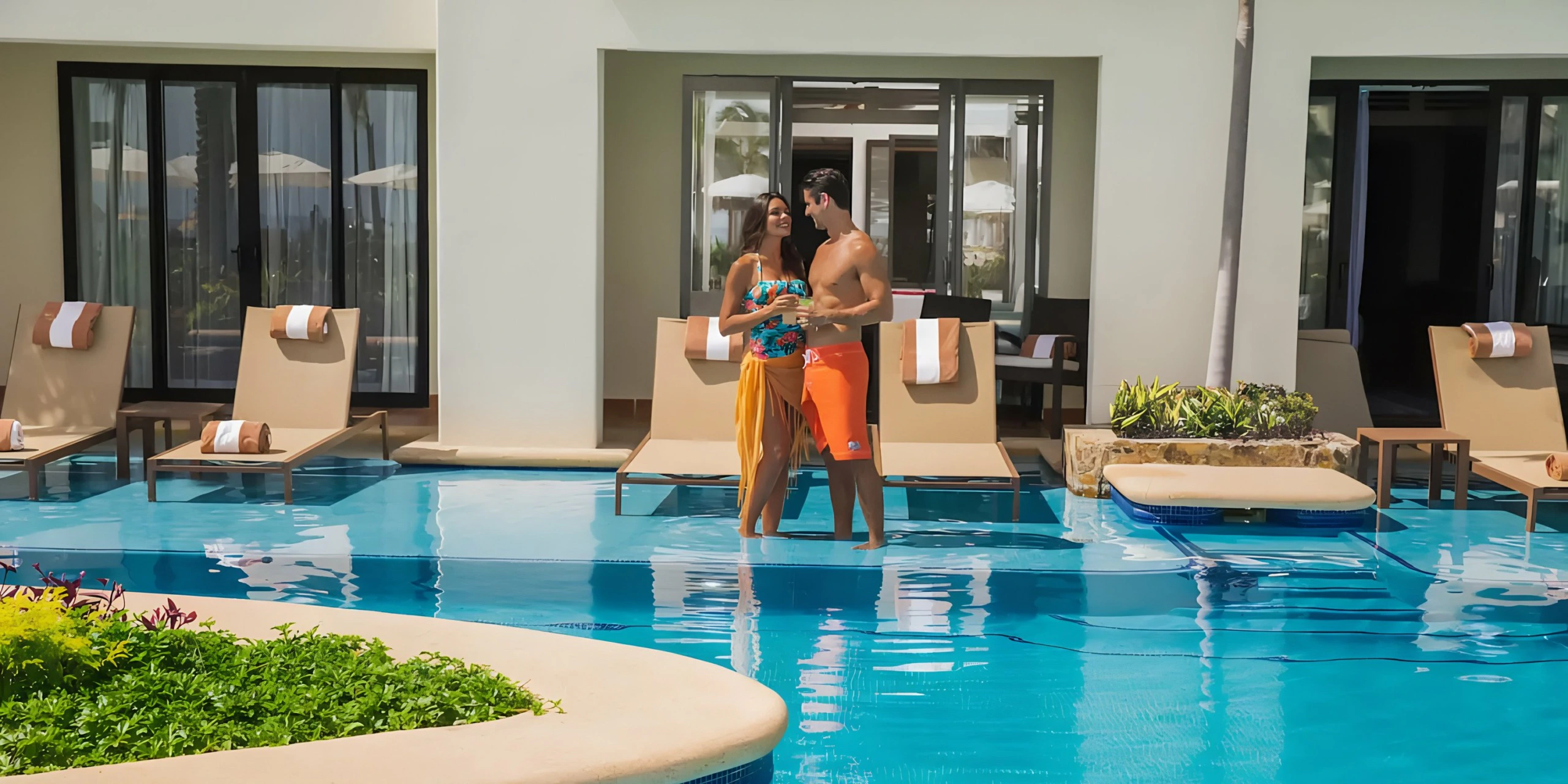 Couple relaxing with cocktails at the infinity pool overlooking the Sea of Cortez at Hyatt Ziva Los Cabos.