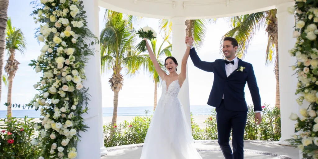Newlywed couple celebrating inside the beachfront wedding gazebo at Hyatt Ziva Los Cabos.