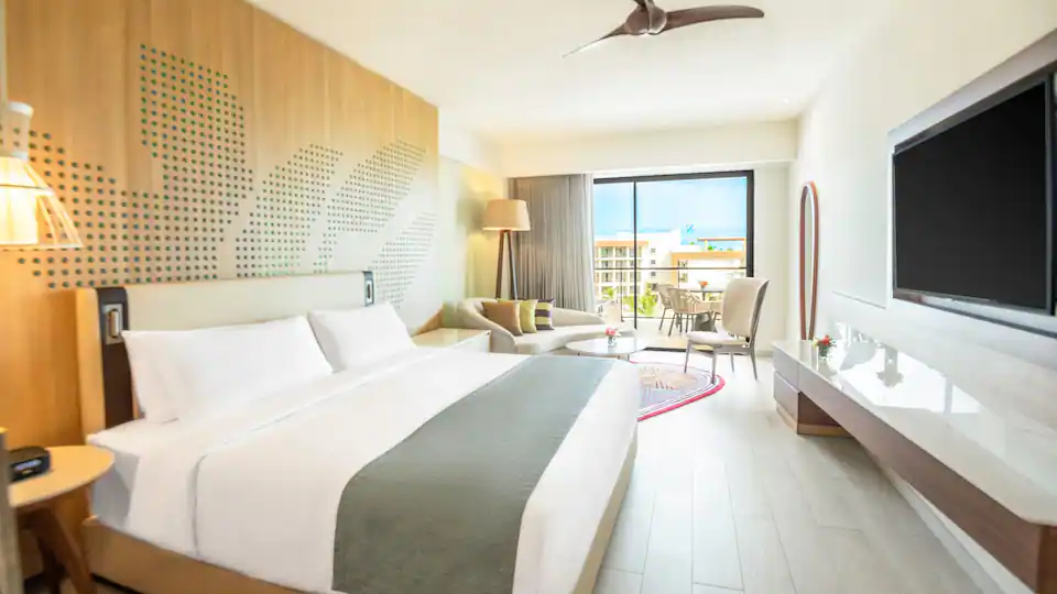 Club Ocean View One Bedroom Master Suite bedroom with king bed, sitting area, and ocean-view balcony at Hyatt Ziva Cap Cana.