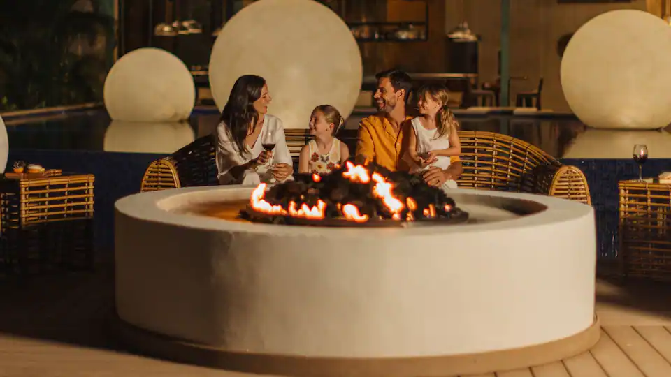 Family gathered around a fire pit at Hyatt Ziva Cap Cana enjoying an evening together at the luxury all-inclusive resort.