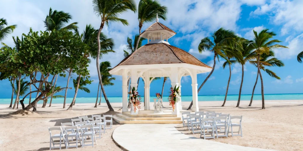 Beachfront wedding gazebo at Hyatt Ziva Cap Cana set on white sand with palm trees and turquoise Caribbean waters in the background.