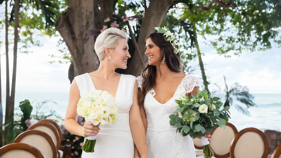 Newly married couple celebrating their beachfront wedding ceremony at Hyatt Ziva Puerto Vallarta with ocean views in the background.