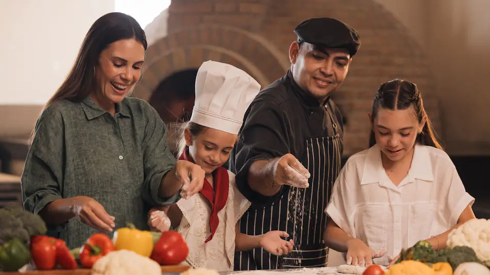 Family learning to make pizza with a resort chef during a cooking class at Hyatt Ziva Puerto Vallarta.