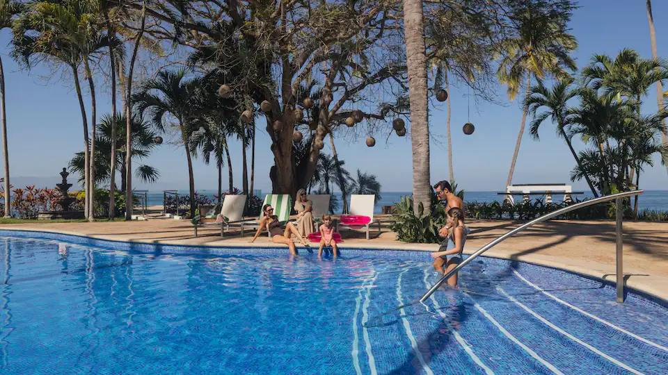 Family enjoying the Palmas Terrace Pool at Hyatt Ziva Puerto Vallarta surrounded by tropical gardens and ocean views.
