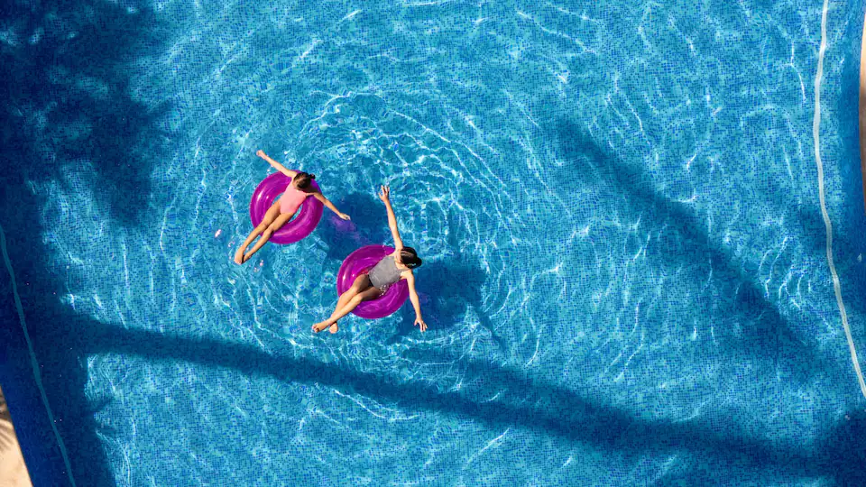 Guests relaxing on pool floats in the Palmas Terrace Pool at Hyatt Ziva Puerto Vallarta with stunning oceanfront surroundings.