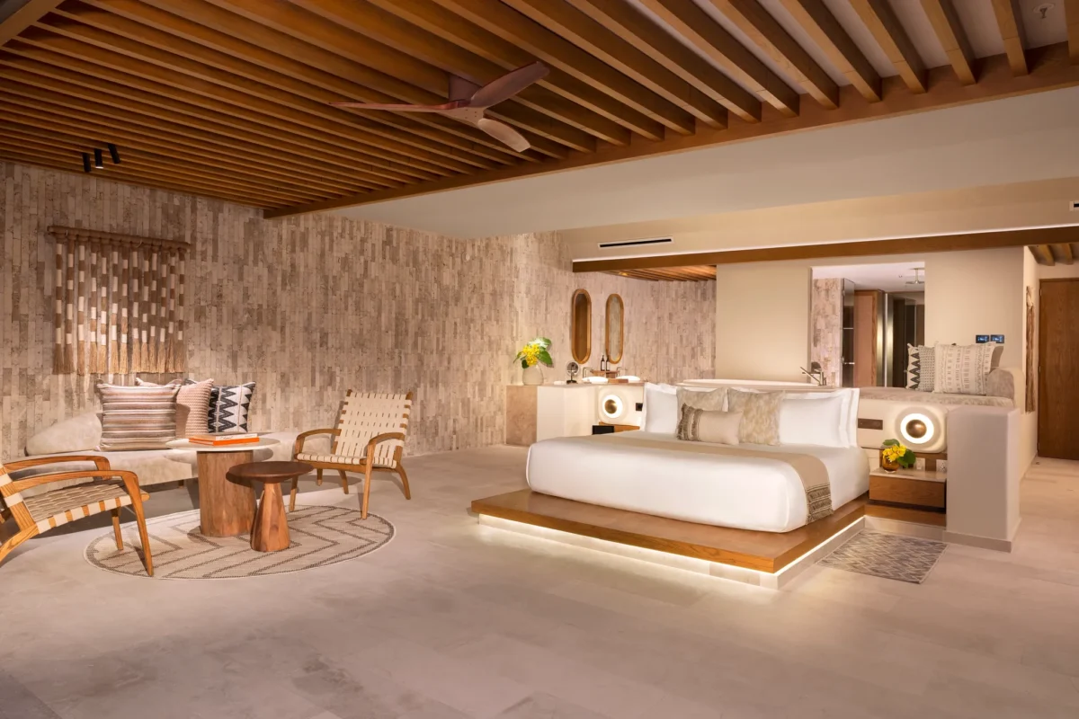 Honeymoon Ocean View suite bedroom with king bed and spacious living area at Impression Isla Mujeres by Secrets.