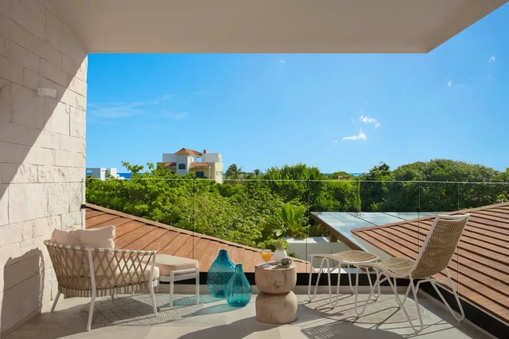 Junior Suite King terrace with lounge seating and tropical view at Impression Isla Mujeres by Secrets.