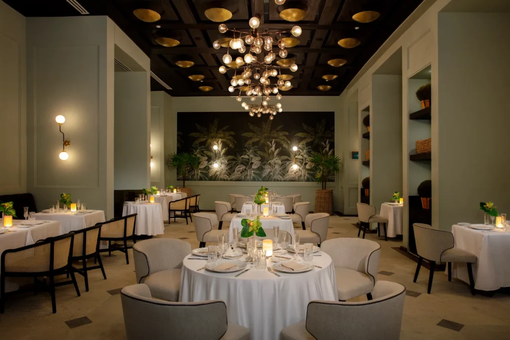 Bisou French restaurant at Impression Moxché by Secrets featuring elegant formal dining, crystal chandeliers, candlelit tables, and refined décor.