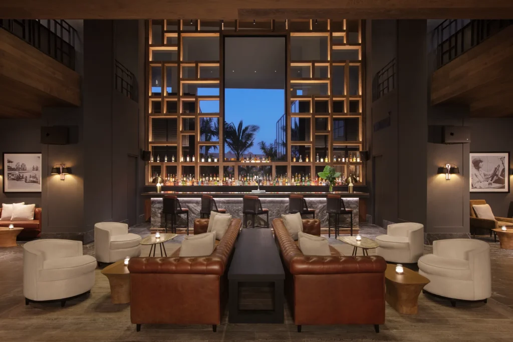 Dark Horse sports bar at Impression Moxché by Secrets featuring a modern cocktail bar, leather lounge seating, and upscale nightlife ambiance.
