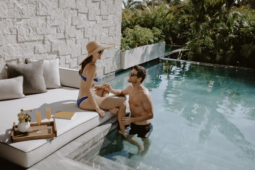 Romantic couple enjoying drinks beside their swim-out pool at Impression Moxché by Secrets.